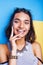 Young cheerful indian mixed races girl happy smiling, posing on blue background in summer fashion clothers. lifestyle