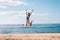 Young cheerful jumping teenage girl excitement at seaside