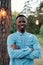 Young cheerful man of African ethnicity in denim shirt keeping his arms crossed