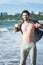 Young cheerful man topless outdoor portrait hiking near the sea