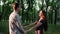Young cheerful married couple is happy and dancing holding hands in Park at sunset
