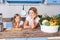 Young cheerful mother and little daughter leaning on table, standing in kitchen, vegan nutrition, healthcare