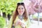 Young cheerful natural woman holding cherry blossom at springtime