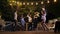 Young cheerful people in cafe at night with firework sparklers.