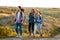 Young cheerful travelers with backpacks smiling, walking in canyon.