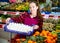 Young cheerful woman salesman carrying box with fresh mushrooms