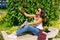 Young cheerful woman takes selfie from hands with phone while sitting on park