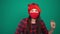 Young cheerful woman wearing red medical mask in christmas santa hat dancing