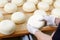 Young cheese-wheels checked by a cheesemaker