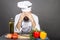 Young chef covers face with hands, having problems,