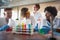 Young chemistry students having a good time in a laboratory while working with colorful chemical. Science, chemistry, lab, people