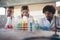 Young chemistry students in a laboratory are astonished by colorful chemical reactions. Science, chemistry, lab, people