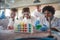 Young chemistry students in a laboratory are excited while watching colorful chemical reactions. Science, chemistry, lab, people