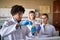 Young chemistry students in a protective gear mix some chemicals in the university laboratory. Science, chemistry, lab, people