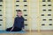 Young child boy sitting and relaxiong on the floor inside sports room in a school after training