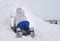 Young child crawling into a snow fort build in a backyard. Hide and seek. Winter fun.