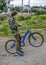 Young child dressed in army clothes  with a bicycle on a walk in the park