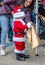 Young child dresses up as santa clause during a Halloween event, but his golden bag holds candy