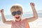 Young Child Flexing Muscles on Beach