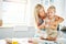 Young child getting help to knead bread dough