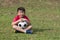 Young child kick soccer ball in green grass field