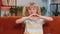 Young child kid girl makes symbol of love, showing heart sign to camera, express romantic feelings