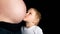 Young child kissing his mothers pregnancy bump