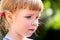 Young child, little girl simple portrait, face expression detail extreme closeup, outdoors scene, blurred background