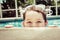 Young child peeking out of pool