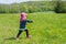 Young child is playing on summery flower meadow with soap bubbles