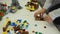 A young child plays in the constructor. Game of the children`s designer. Colored cubes. Small arms are connected cubes