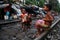 A young child plays his drum as two other children look on in a slum in Kolkata