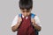 Young child in school uniform feeling sad and depressed looking down scared and embarrassed victim of bullying and abuse