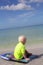 Young Child Sitting on Boogie Board in Ocean