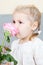 Young child smelling a pink rose