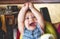 Young child throwing a tantrum in a high chair in a restaurant