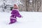 Young child walks in snow at winter snowy day.