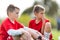 Young children players football match on soccer field - boys watching game