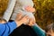 Young children sit next to a pregnant woman and hold their hands on their mother`s belly in the forest in nature