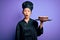 Young chinese chef woman wearing cooker uniform and hat holding tray with cake scared in shock with a surprise face, afraid and