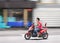 Young Chinese man on motorized scooter trushing through  a street.