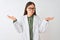 Young chinese scientist woman wearing coat and glasses over isolated white background clueless and confused expression with arms