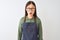 Young chinese shopkeeper woman wearing apron and glasses over isolated white background afraid and shocked with surprise