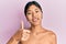 Young chinese woman standing topless showing skin doing happy thumbs up gesture with hand