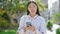 Young chinese woman using smartphone smiling at park