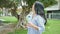 Young chinese woman using smartphone smiling at park