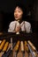 Young chinese woman violin maker showing the neck of the violins under construction