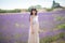 Young Chinese woman in white traditional dress, walking in lavender field. Plateau de Valensole, Alpes-de-Haute-Provence, Provence