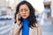 Young chinese woman worried talking on the smartphone at street