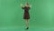 A young Christmas woman is circling under the snowfall on the green screen